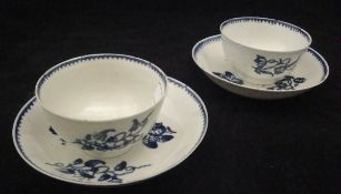 Two late 18th Century English blue and white pottery tea bowls and saucers with floral spray and