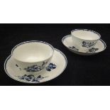 Two late 18th Century English blue and white pottery tea bowls and saucers with floral spray and