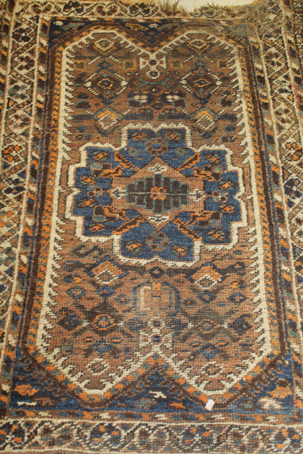 A Caucasian rug, the central panel set with a stylised flower head medallion on a mushroom ground,