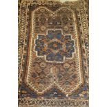 A Caucasian rug, the central panel set with a stylised flower head medallion on a mushroom ground,