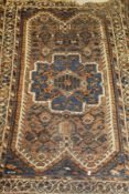 A Caucasian rug, the central panel set with a stylised flower head medallion on a mushroom ground,