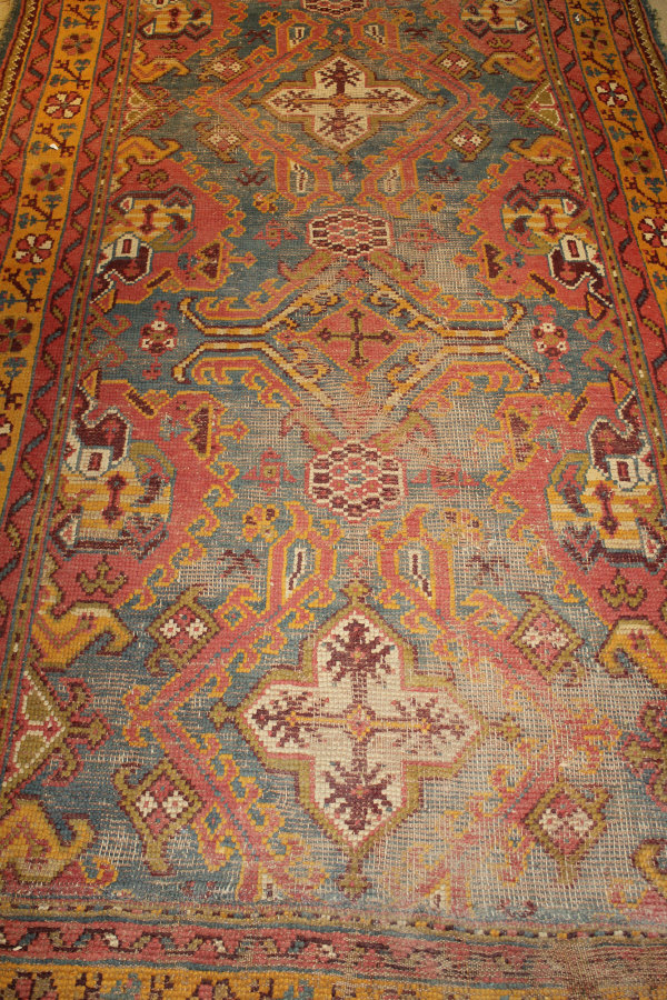 A Turkish style rug, the central panel set with various geometric patterns on a teal ground,