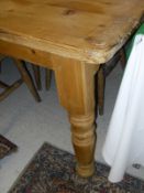 A rectangular pine plank top kitchen table on turned legs