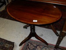 A mahogany and rosewood cross-banded oval-topped occasional table on turned pedestal to three