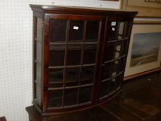 A circa 1900 mahogany bow fronted glazed and barred two door display cabinet with two shelves