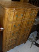 A continental style chest of five long drawers with shaped front, brass handles, cabriole legs,
