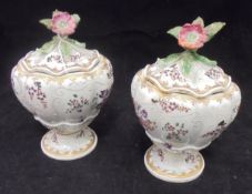 A pair of Sampson armorial lidded vases of squash form with flower finials raised on a circular