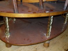 A two tier oval mahogany coffee table with twisted brass supports to oak block feet