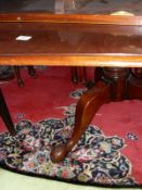 A 20th Century mahogany triple pillar dining table,