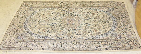 A Kashan carpet, the central panel set with floral decorated medallion on a mint ground,