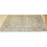 A Kashan carpet, the central panel set with floral decorated medallion on a mint ground,
