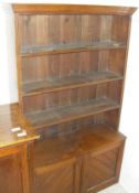 A circa 1900 walnut open bookcase of four tiers over two cupboard doors