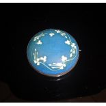 A Ruskin ceramic brooch decorated with floral motifs on a blue ground, stamped "Ruskin" to back,