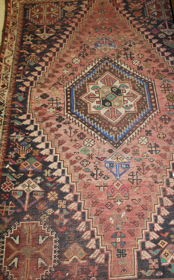 A Caucasian rug, the centre field with repeating hexagonal medallions in terracotta,