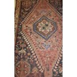 A Caucasian rug, the centre field with repeating hexagonal medallions in terracotta,