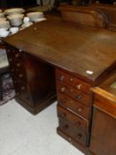 A 19th Century mahogany writing desk with sloped top to pedestals of five graduated drawers,