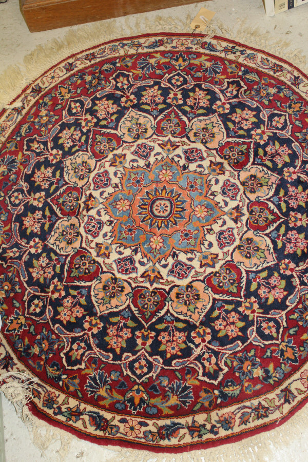 A Persian rug, the central panel set with stylised floral medallion on a red, blue and cream ground,