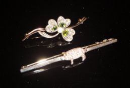A white metal bar brooch set with a pig set with diamonds,