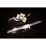 A white metal bar brooch set with a pig set with diamonds,