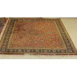 A Tabriz rug with all over foliate decoration on a deep pink ground,