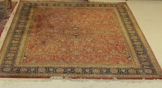 A Tabriz rug with all over foliate decoration on a deep pink ground,