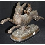 A modern bronze study of a frog riding up on the back of a hare,