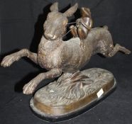 A modern bronze study of a frog riding up on the back of a hare,