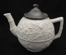 An early 19th Century relief ware bullet shaped pottery teapot with all over prunus blossom
