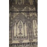A Persian rug, the central panel set with reflected architectural design on a fawn ground,