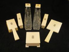 A George V ivory dressing table set of seven pieces comprising three brushes, mirror,