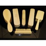A selection of five late Victorian ivory backed brushes and a nail buffer