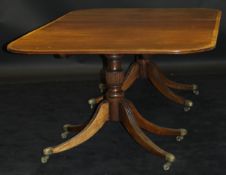 A mahogany rounded rectangular twin pillar dining table in the George III taste with single extra