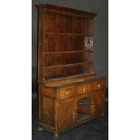 An 18th Century oak dresser with moulded pediment above three tier boarded plate rack on a base of