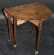 An 18th Century oak oval drop-leaf tea table with central bog oak and holly starburst inlaid
