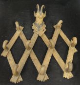 A Black Forest carved folding coat rack, the top decorated with carved Chamois head,