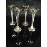 A set of four Edwardian loaded silver spill vases of flared trumpet form,