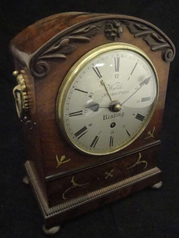 A circa 1835 flamed mahogany brass inlaid bracket alarm clock, the dial marked "Walsh, Market Place,