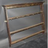 A 19th Century oak three tier wall hanging plate rack with moulded pediment, 136.