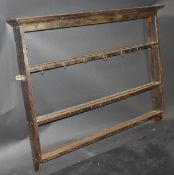 A 19th Century oak three tier wall hanging plate rack with moulded pediment, 136.