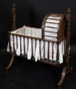 An early 19th Century mahogany rocking crib, the body with turned spindles,