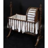 An early 19th Century mahogany rocking crib, the body with turned spindles,