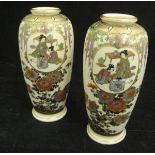 A pair of Japanese Meiji Period Satsuma vases decorated with panels of figures in an interior
