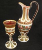 A Victorian Bohemian ruby and enamelled overlaid glass ewer with matching goblet decorated with
