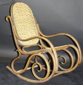 An early 20th Century bentwood rocking chair in the manner of Thonet with cane seat and back, 52.
