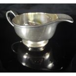 A modern silver sauceboat in the Art Deco manner, the plain body with reeded edge,