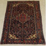 A Caucasian rug, the central panel set with floral decorated medallion on a dark blue ground,