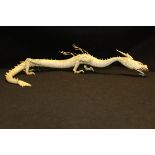 A Japanese Meiji Period carved ivory articulated dragon, the legs with stylised flames,