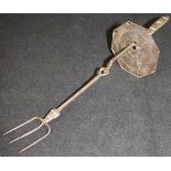 A charcoal iron toasting fork with shield, designed by Ernest Gimson, made by Alfred Bucknell,