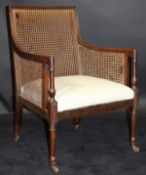 A 19th Century mahogany framed bergère library chair with caned back and arms and upholstered seat,