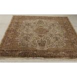 An Indian rug, the central panel set with floral decorated medallion on a mushroom coloured ground,